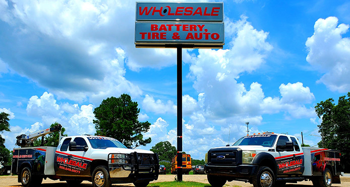 Technician performing auto repair service inside the Wholesale Battery, Tire and Auto shop